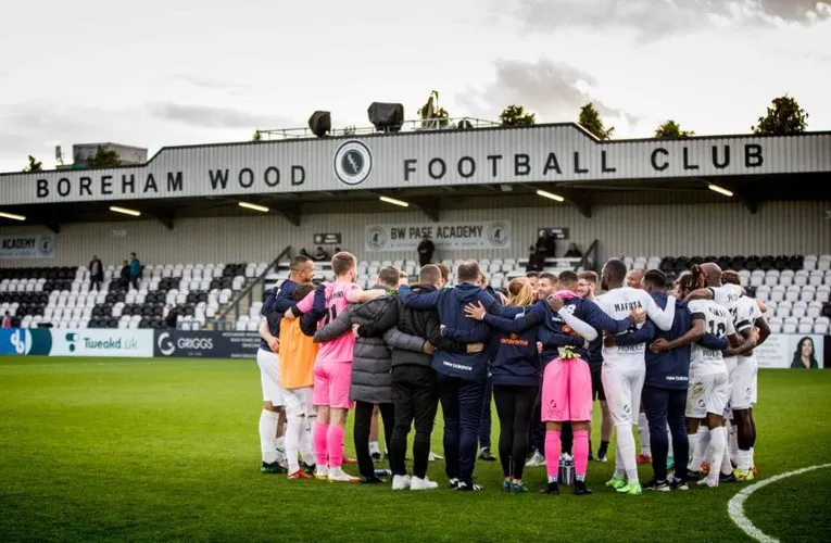 Đội hình Boreham Wood FC đứng trước khán đài chính tại sân Meadow Park