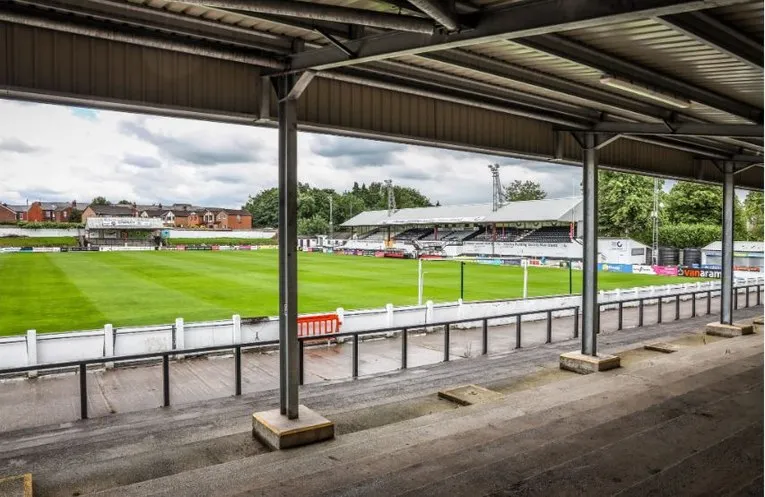 Góc nhìn từ khán đài đứng (terraces) tại Victory Park, Chorley, mang đến trải nghiệm độc đáo về không khí trận đấu bóng đá hạng thấp ở Anh.