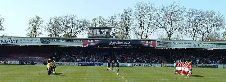 Hình ảnh khai cuộc một trận đấu tại sân vận động Bootham Crescent, cho thấy không khí thi đấu