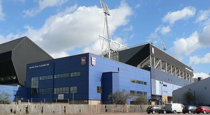 Khán đài South Stand của sân Portman Road, với hàng ghế xanh đặc trưng và cấu trúc hai tầng, nơi người hâm mộ Ipswich cổ vũ.