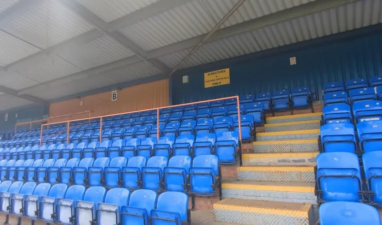 Khu vực khán đài có ghế ngồi tại sân Cressing Road, nơi người hâm mộ Braintree Town FC theo dõi các trận đấu kịch tính.