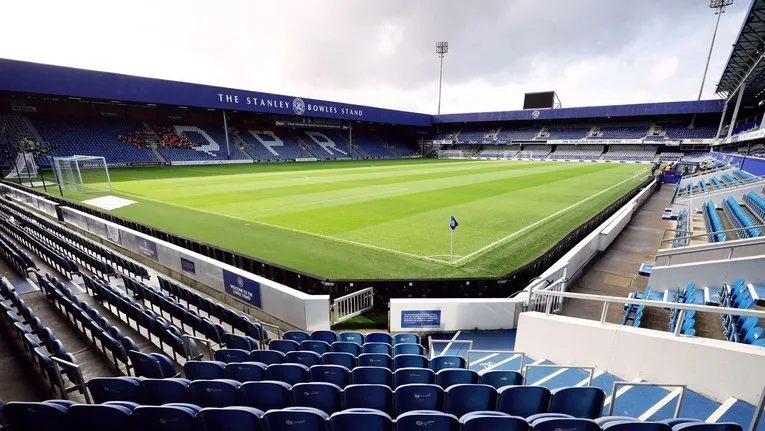 Khung cảnh mặt cỏ sân Loftus Road nhìn từ khán đài, nơi diễn ra các trận đấu đầy kịch tính của bóng đá Anh.
